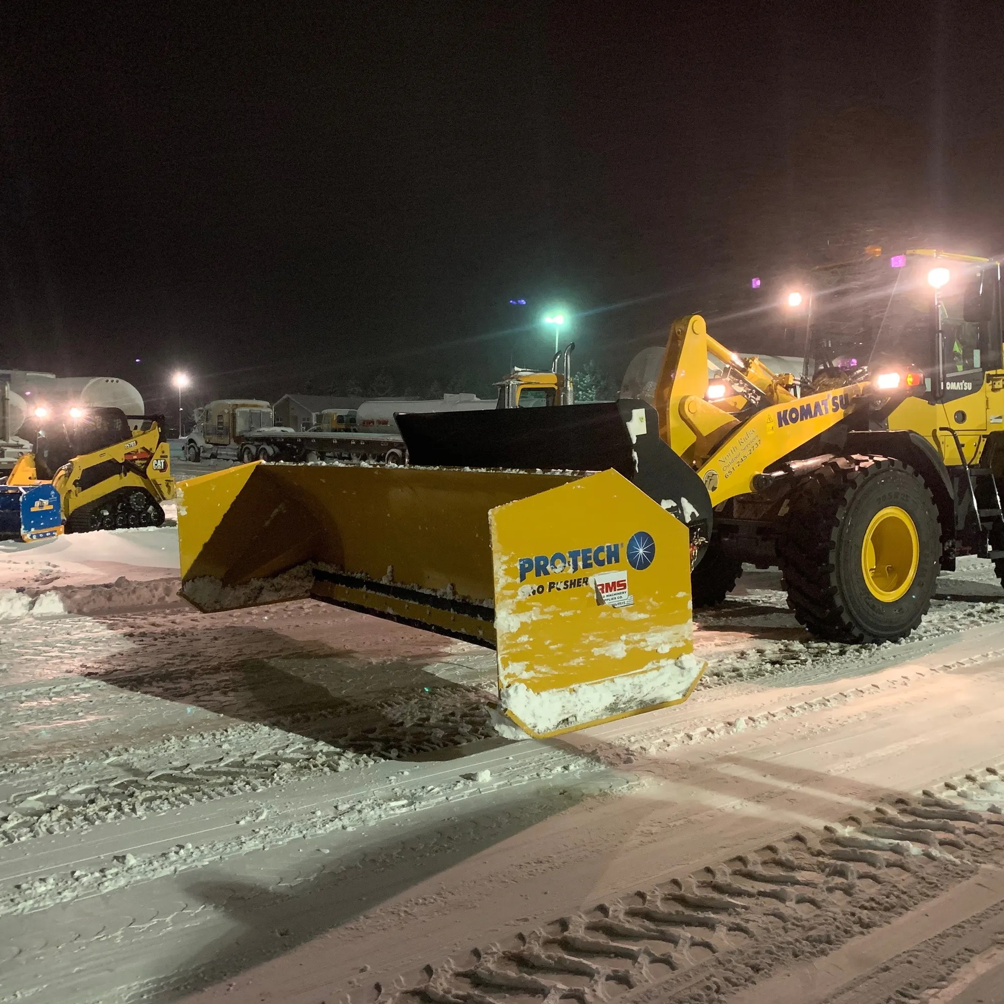 Snow plowing equipment clearing a commercial parking lot in Twin Cities winter